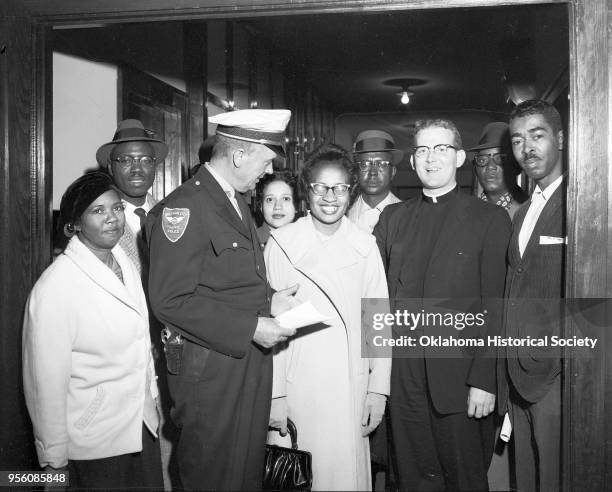 Photograph of, left to right, Mrs Ella Floyd, Ed Stamps, a police officer, Mrs Freddie Moon, Clara Luper, Dr EC Moon, Father Robert McDole, A Willie...