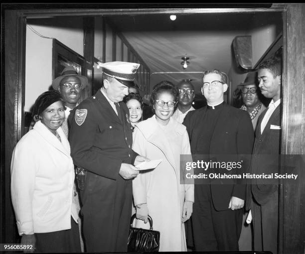 Photograph of, left to right, Mrs Ella Floyd, Ed Stamps, a police officer, Mrs Freddie Moon, Clara Luper, Dr E C Moon, Father Robert McDole, A Willie...
