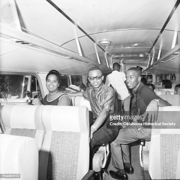 Photograph of Robert Dowell, with his hand on his chest, Linda Pogue boarding chartered bus at Douglas High School, for the National NAACP Convention...