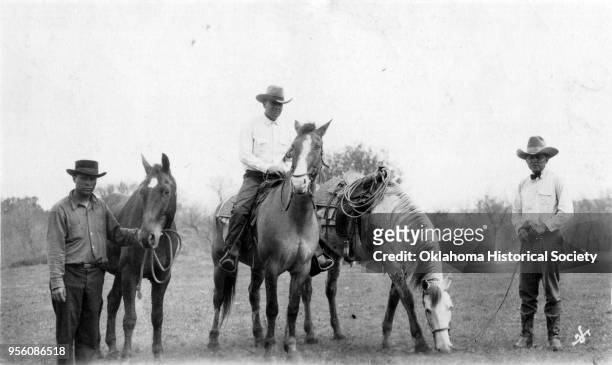 Photograph of Bill McKinley who is on a horse, and two unidentified Osage men with horses after a rodeo, early twentieth century.