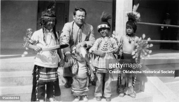 Photograph of Jim Thorpe with four Sac and Fox children who are, left to right, Carl Philip's son, an unidentified child, Bill's son, and another...