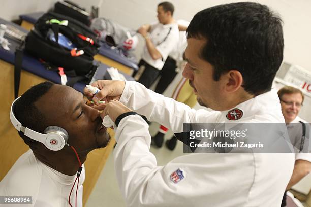 Vernon Davis of the San Francisco 49ers has eye drops applied to his eyes by a doctor prior to the NFL game against the St. Louis Rams at Edward...