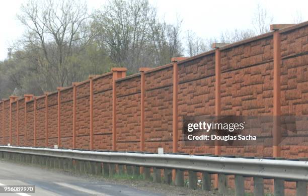 concrete wall used as a noise and acoustical barrier on the highway - barrier highway fotografías e imágenes de stock