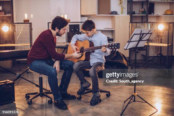 junge in der musikschule - vater sohn musik stock-fotos und bilder