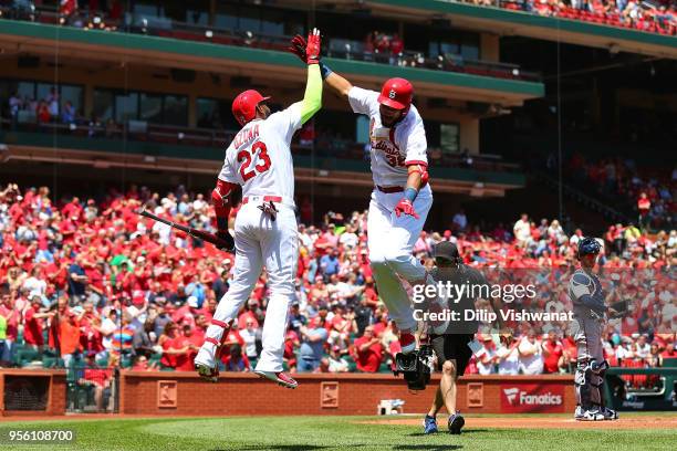 Jose Martinez of the St. Louis Cardinals celebrates with Marcell Ozuna after hitting a home run against the Minnesota Twins in the first inning at...