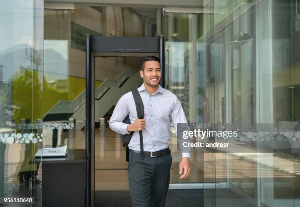 handsome young businessman leaving a business center holding his backback very happy - leaving office stock pictures, royalty-free photos & images