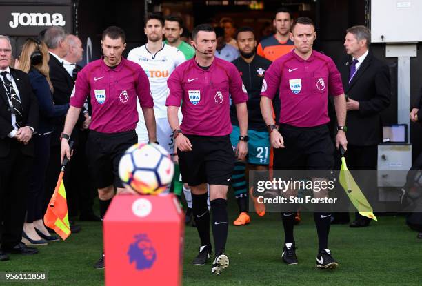 Match referee, Michael Oliver walks the two sides out onto the pitch during the Premier League match between Swansea City and Southampton at Liberty...