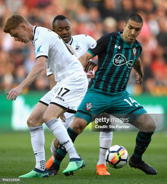 Oriol Romeu of Southampton and Samuel Clucas of Swansea City clash during the Premier League match between Swansea City and Southampton at Liberty...