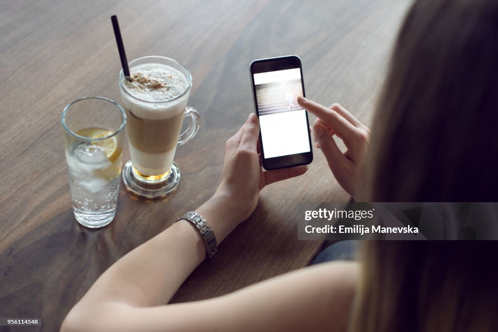 Close up of young beautiful woman using mobile phone