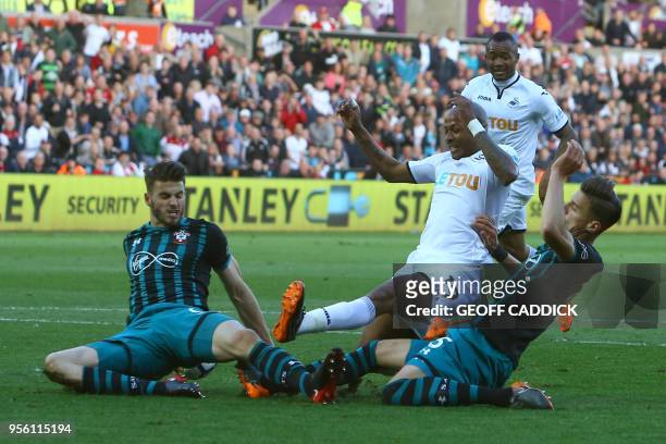 Swansea's Ghanaian striker Andre Ayew vies with Southampton's Polish defender Jan Bednarek during the English Premier League football match between...