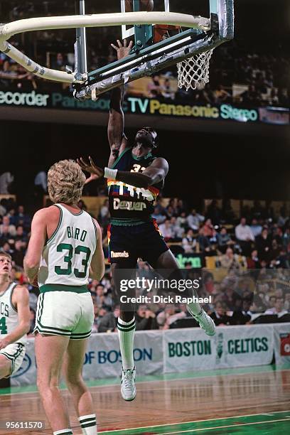 Kevin McKenna of the Denver Nuggets shoots a layup against Larry Bird of the Boston Celtics during a game played in 1985 at the Boston Garden in...