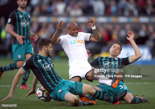 Swansea City's Andre Ayew battles for the ball with Southampton's Jan Bednarek and Wesley Hoedt during the Premier League match at the Liberty...