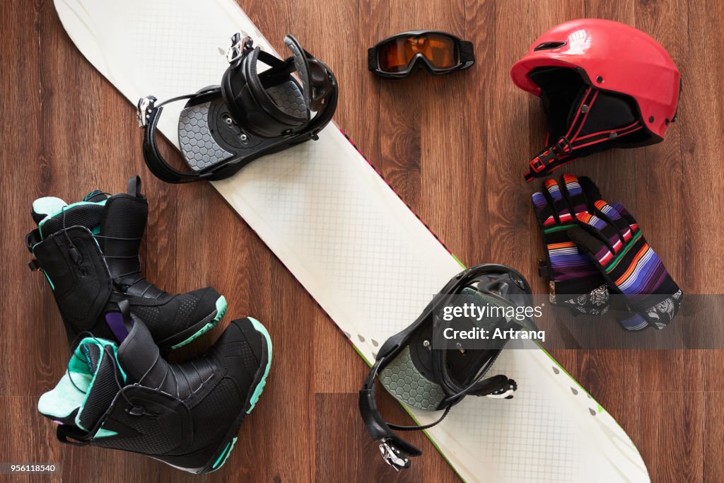 一套滑雪板靴, 頭盔, 手套和麵具在木