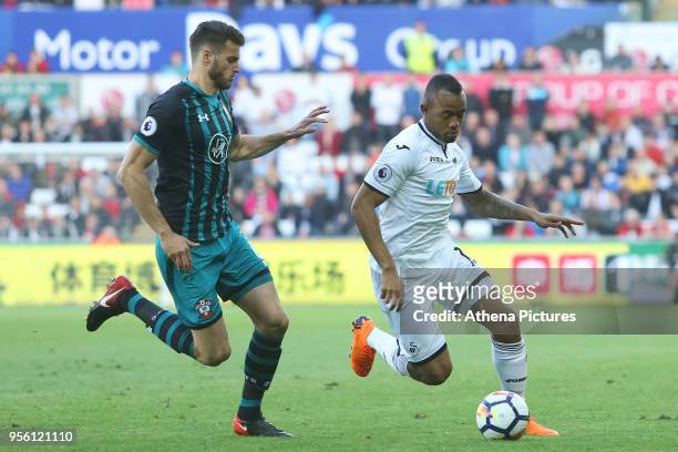 Jordan Ayew of Swansea City is marked by Jack Stephens of Southampton during the Premier League match between Swansea City and Southampton at Liberty...