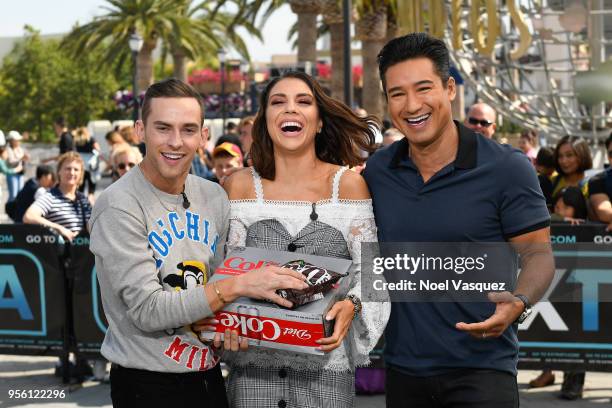Mario Lopez gives a gift of Diet Coke and M&M's to Adam Rippon and Jenna Johnson visit "Extra" at Universal Studios Hollywood on May 8, 2018 in...