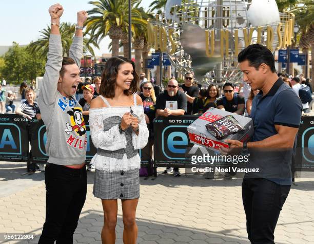 Mario Lopez gives a gift of Diet Coke and M&M's to Adam Rippon and Jenna Johnson visit "Extra" at Universal Studios Hollywood on May 8, 2018 in...