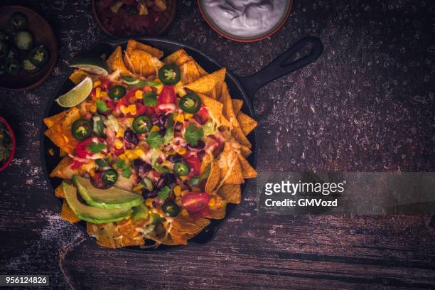 essen nachos tortillachips mit salsa und jalapeños - tortilla chip stock-fotos und bilder
