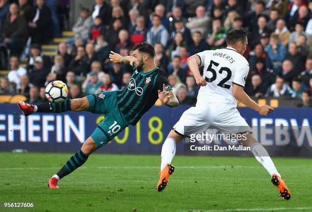 Charlie Austin of Southampton takes a shot on goal under pressure from Connor Roberts of Swansea City during the Premier League match between Swansea...