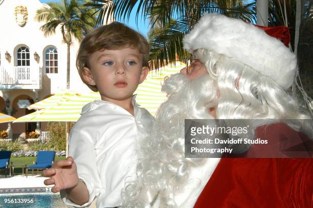 Barron Trump, son of Donald and Melania Trump, is carried by Santa Claus on Christmas Day at the Mar-a-Lago estate in Palm Beach, Florida, December...