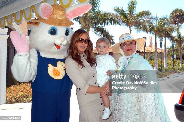 Melania Trump carries son Barron while flanked by the Easter Bunny, left, and an unidentified Easter Sunday character, at the Mar-a-Lago Club on...