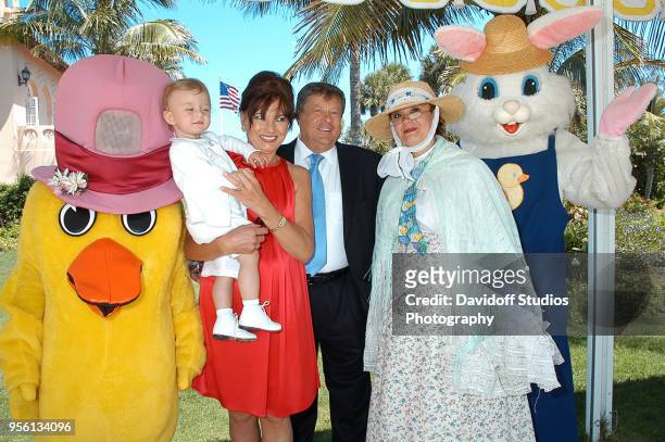 Barron Trump, second from left, is held by grandmother Amalija Knavs who stands next to husband Viktor Knavs during Easter Sunday events at the...