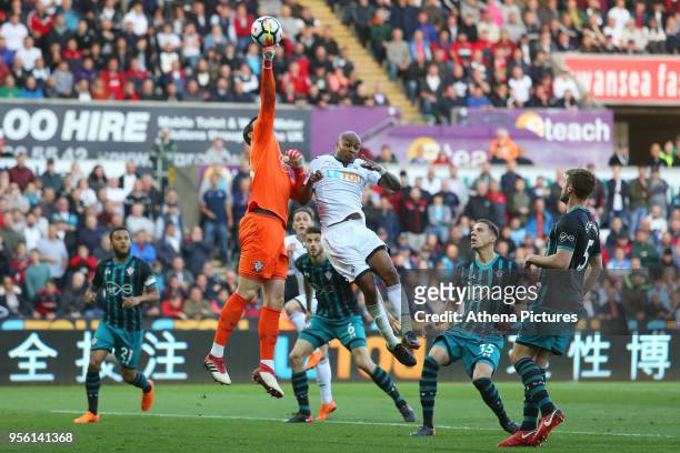 Alex McCarthy of Southampton punches the ball away Andre Ayew of Swansea City during the Premier League match between Swansea City and Southampton at...