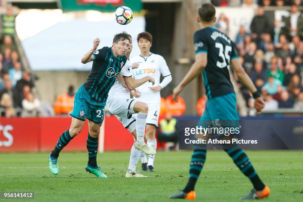 Pierre-Emile Hojbjerg of Southampton heads the ball away from Andy King of Swansea City during the Premier League match between Swansea City and...