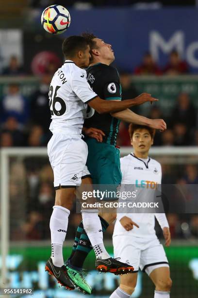 Swansea City's English defender Kyle Naughton vies in the air and clashes heads with Southampton's Danish midfielder Pierre-Emile Hojbjerg during the...