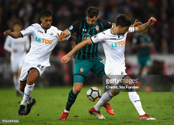 Kyle Naughton and Federico Fernandez of Swansea City hold off Charlie Austin of Southampton during the Premier League match between Swansea City and...