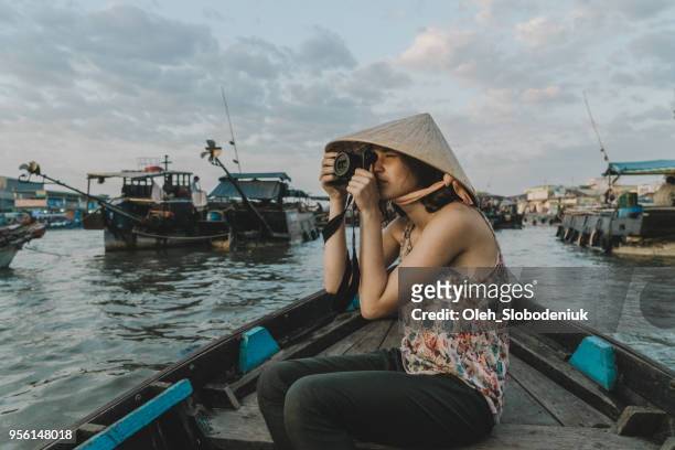 woman taking photo while  riding on boat through mekong delta and floating market - hot vietnamese women stock pictures, royalty-free photos & images