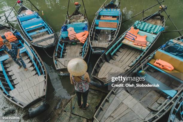 vrouw stond in de buurt van de boten op de mekongdelta - asian style conical hat stockfoto's en -beelden