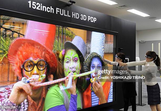 Panasonic employees unveil a prototype model of the world's largest 152-inch sized plasma display panel , during a press preview at the company's...