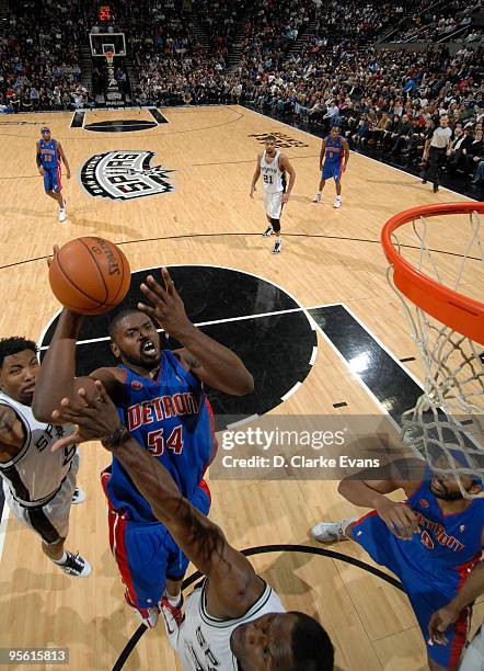 Jason Maxiell of the Detroit Pistons shoots against Roger Mason, Jr. #8 and Antonio McDyess of the San Antonio Spurs on January 6, 2010 at the AT&T...