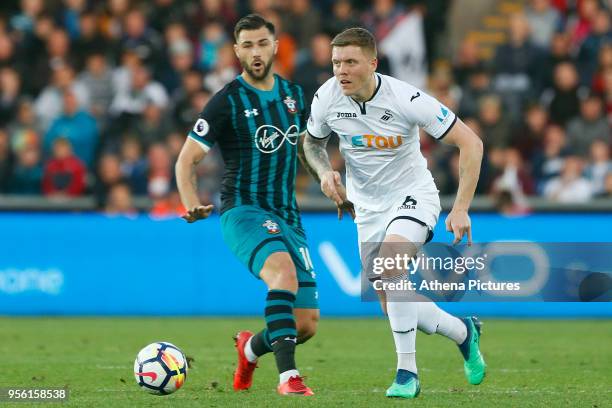 Alfie Mawson of Swansea City is challenged by Charlie Austin of Southampton during the Premier League match between Swansea City and Southampton at...