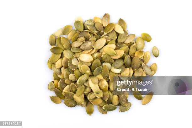 heap of raw pumpkin seeds isolated on white background - pumpkin seed stock pictures, royalty-free photos & images
