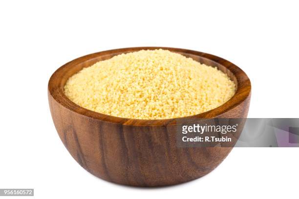 raw couscous in a wooden bowl on white background - クスクス ストックフォトと画像