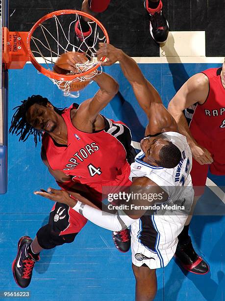 Dwight Howard of the Orlando Magic slam dunks against Chris Bosh of the Toronto Raptors during the game on January 6, 2010 at Amway Arena in Orlando,...