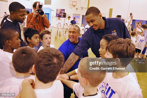 Strength and conditioning coach Steve Hess and Carmelo Anthony of the Denver Nuggets lead students in a cheer at West Middle School as part of the...