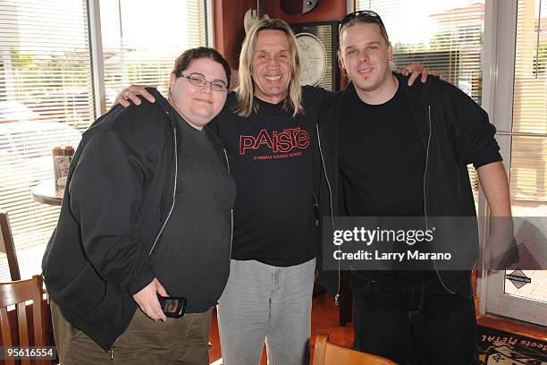 Nicko McBrain of Iron Maiden poses with fans at his restaurant Rock N Roll Ribs on January 6, 2010 in Coral Springs, Florida.