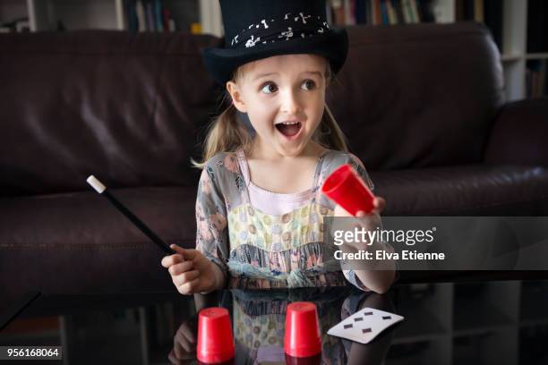 young girl in top hat performing magic trick - goocheltruc stockfoto's en -beelden