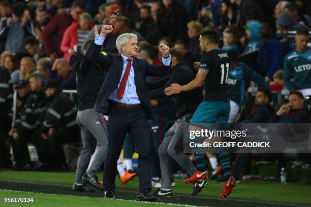 Southampton Welsh manager Mark Hughes and Southampton's Serbian midfielder Dusan Tadic react react following the English Premier League football...