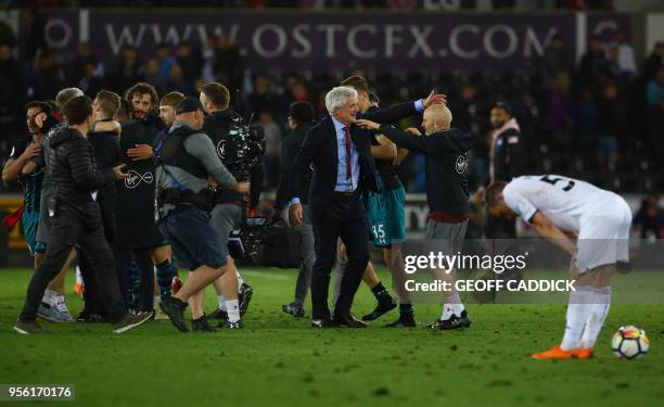 Southampton Welsh manager Mark Hughes celebrates with players and staff following the English Premier League football match between Swansea City and...