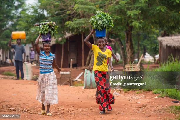 zwei frauen, die nahrung auf eine unbefestigte landstraße, dr congo - congo stock-fotos und bilder