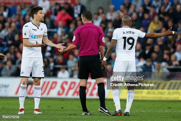 Federico Fernandez of Swansea City and team mate Andre Ayew protest to referee Michael Oliver during the Premier League match between Swansea City...