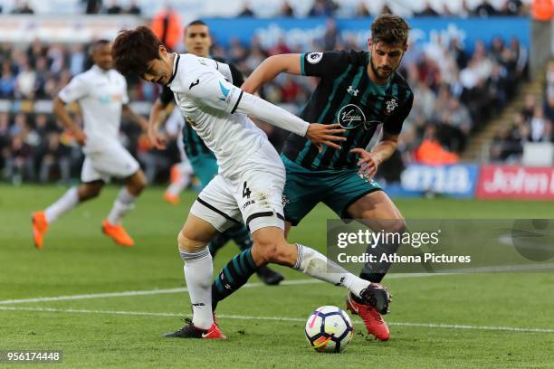 Ki Sung-Yueng of Swansea City challenged by Wesley Hoedt of Southampton during the Premier League match between Swansea City and Southampton at The...