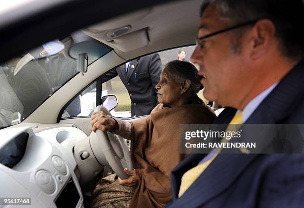 Delhi Chief Minister Sheila Dixit drives the e-Spark car as President and Managing Director, General Motors India, Karl Slym accompanies her during...