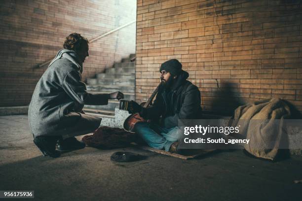 woman helping homeless man - beggar stock pictures, royalty-free photos & images