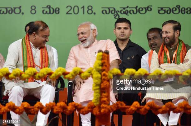 Prime Minister of India Narendra Modi shares a light moment with the Union minister Ananth Kumar as Prakash Javadekar looks on during BJP rally ahead...