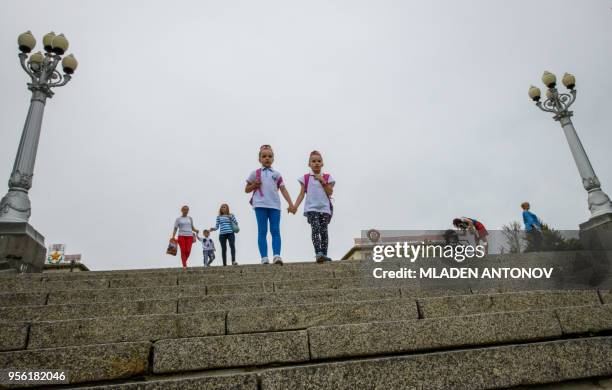 Photo taken on May 8, 2018 shows children passing in front of a building which displays a portrait of Soviet state founder Vladimir Lenin Order in...