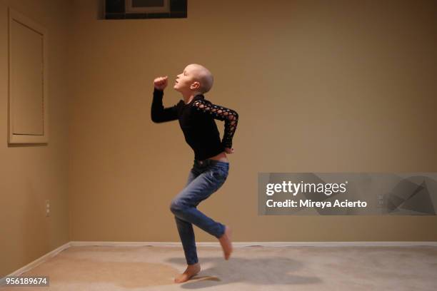 a young girl with cancer dances on her own, in her house. - girls barefoot in jeans fotografías e imágenes de stock